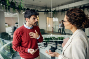 Führungskraft und Mitarbeiter im konzentrierten Gespräch an einem Besprechungstisch